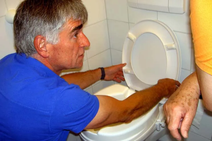 Ein WC-Aufsatz wird montiert vom SRK Kanton Luzern