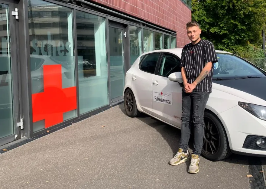 Zivi Marco Brun steht mit seinem Auto vor dem Gebäude des SRK in Luzern.